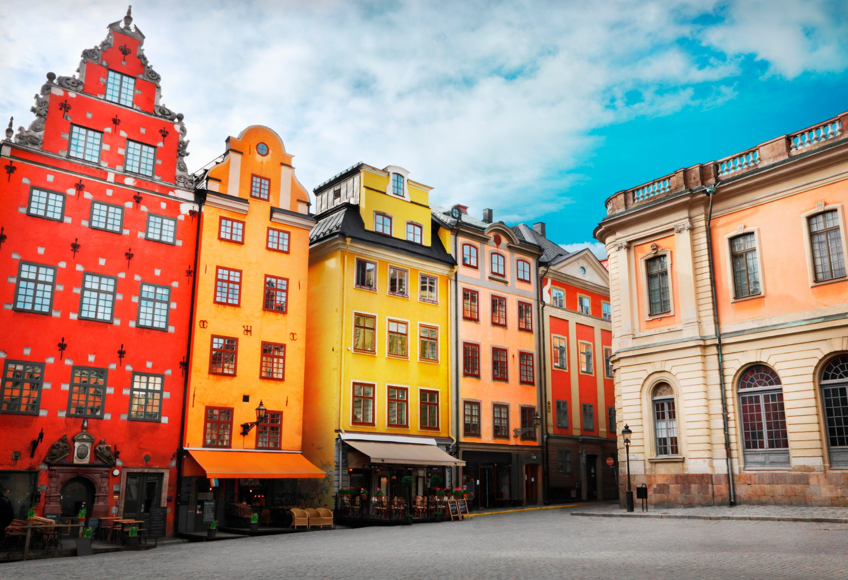 Stockholm's Old Town is shown as vibrant and colorful underneath a blue sky.